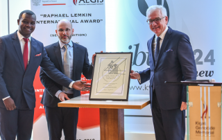 Dr James Smith (centre) and Freddy Mutanguha accept the Raphael Lemkin International Award on behalf of the Aegis Trust.