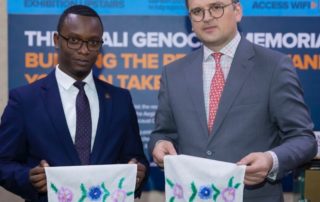 Dmytro Kuleba presents Kigali Genocide Memorial Manager Dieudonne Nagiriwubuntu with a towel embroidered by a Ukrainian woman who survived the Holodomor, 25 May 2023